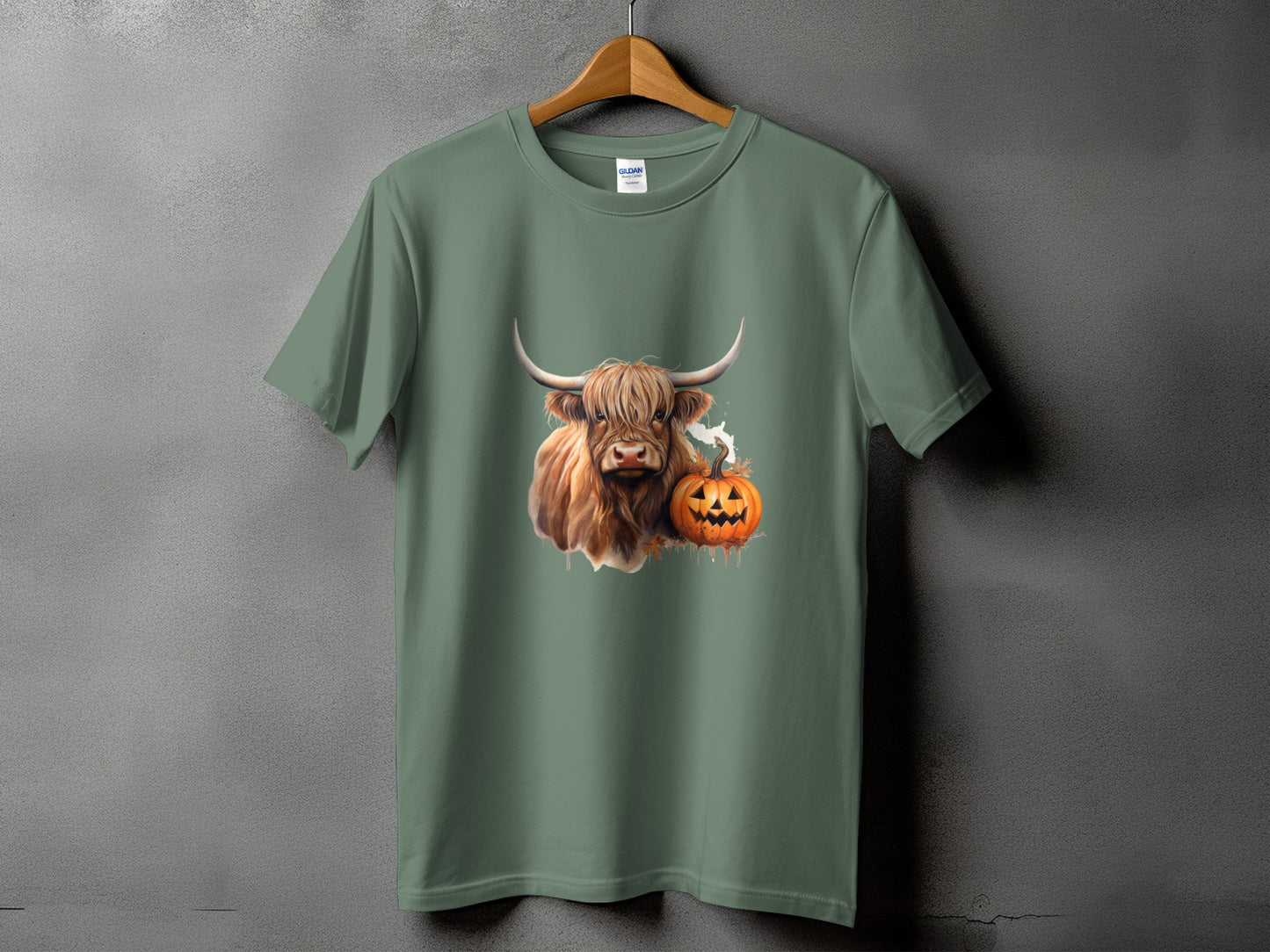 Highland cow and jack-o'-lantern graphic on a sage green t-shirt.