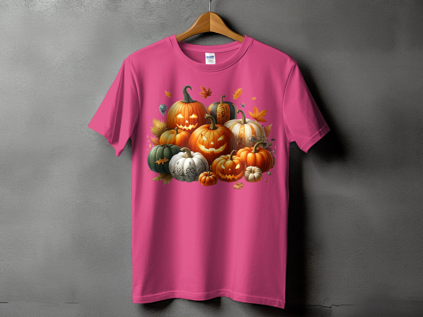 Pink t-shirt featuring a large, colorful illustration of assorted Halloween pumpkins and autumn leaves.