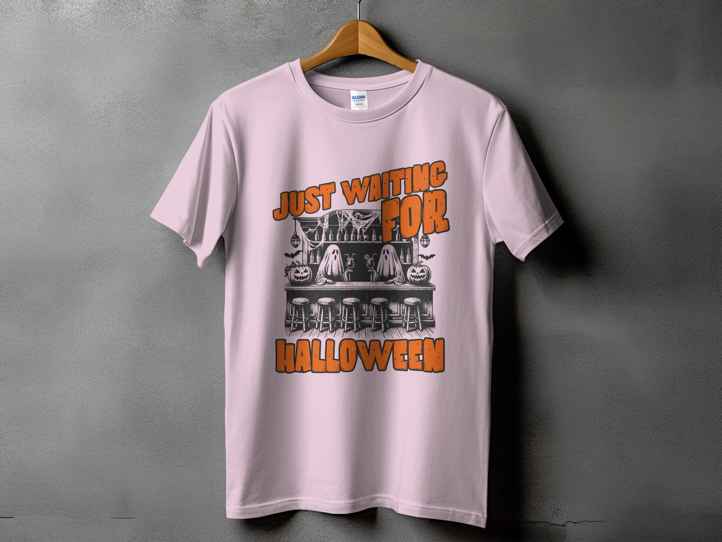Pink t-shirt with "Just Waiting For Halloween" graphic featuring ghosts at a bar.