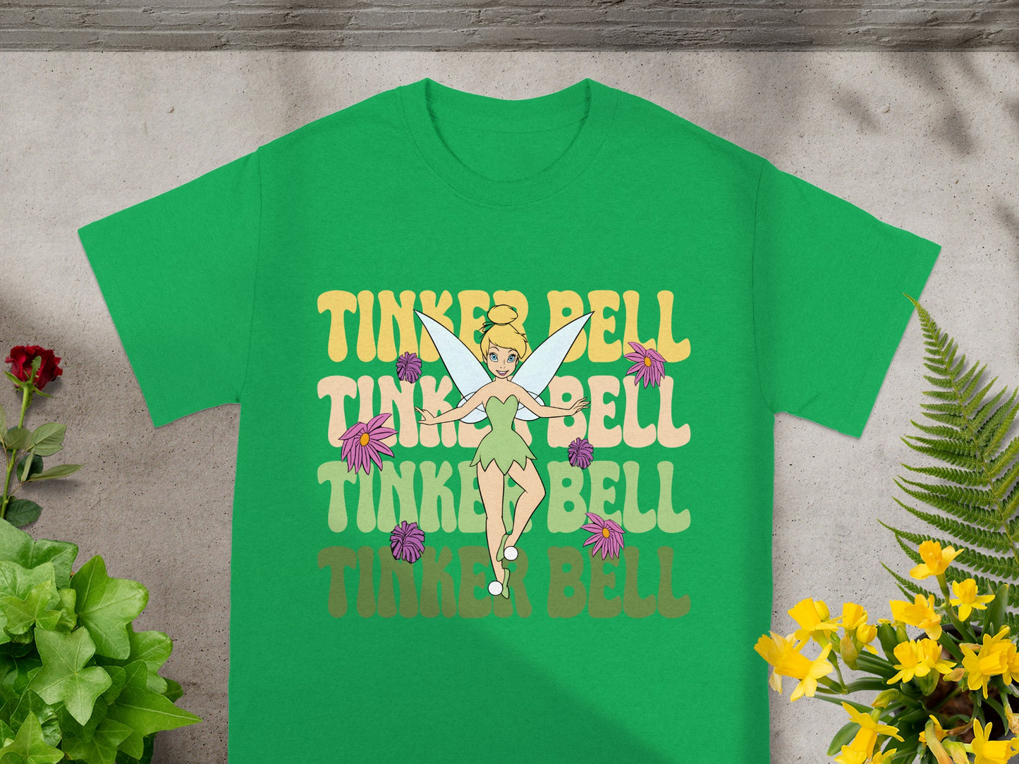 Green t-shirt with Tinker Bell and floral graphic in retro font.