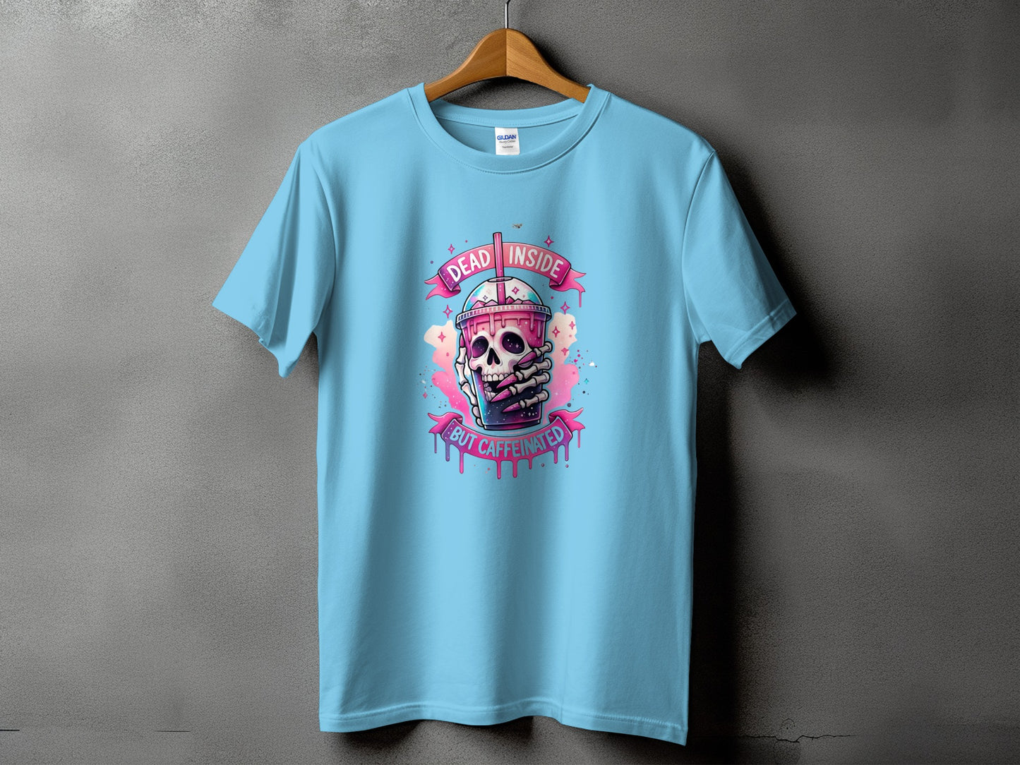 Light blue t-shirt with a skull holding a drink, reading "Dead Inside But Caffeinated".