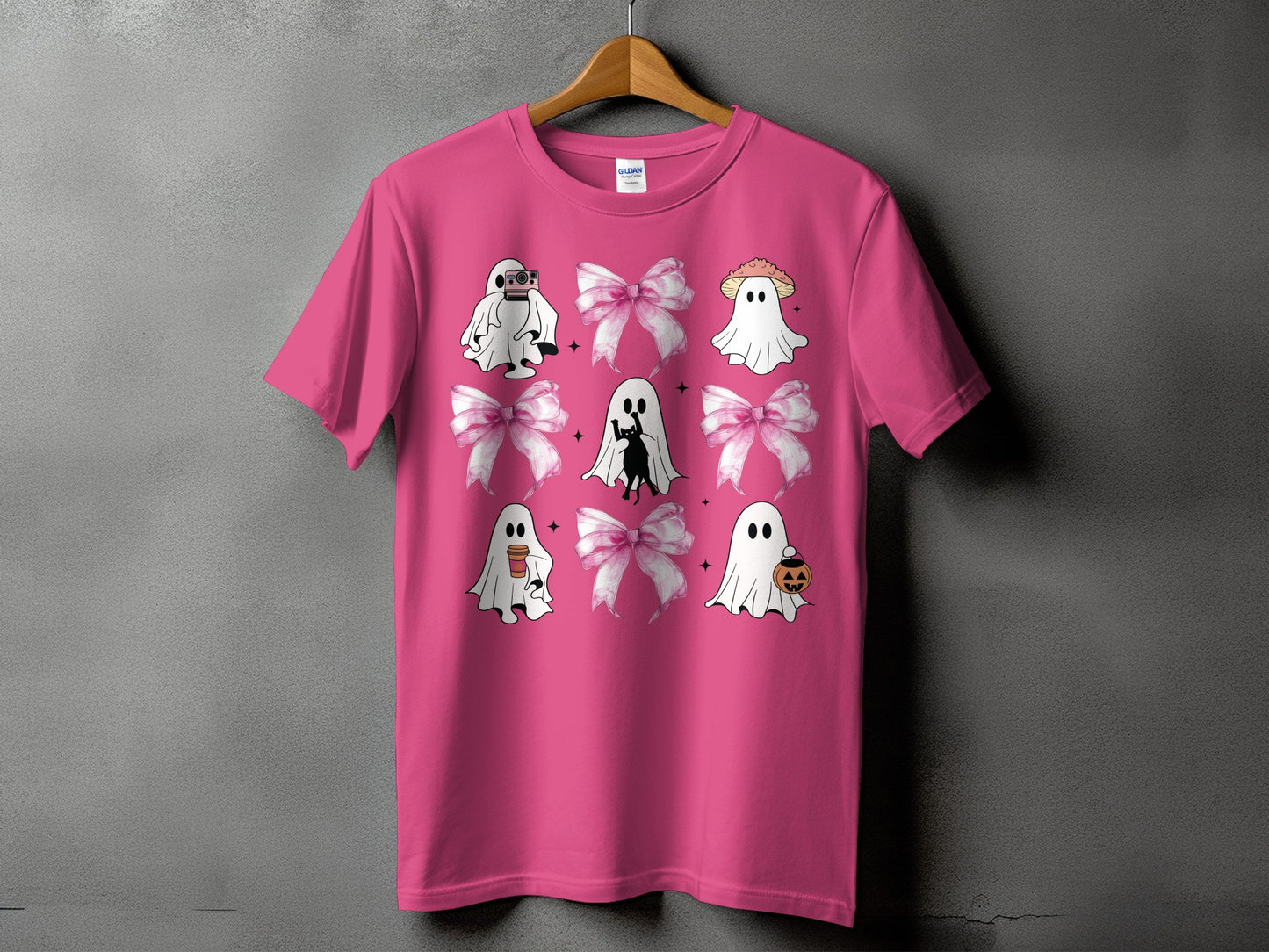 Pink t-shirt with a grid of ghosts, black cat, and bows.
