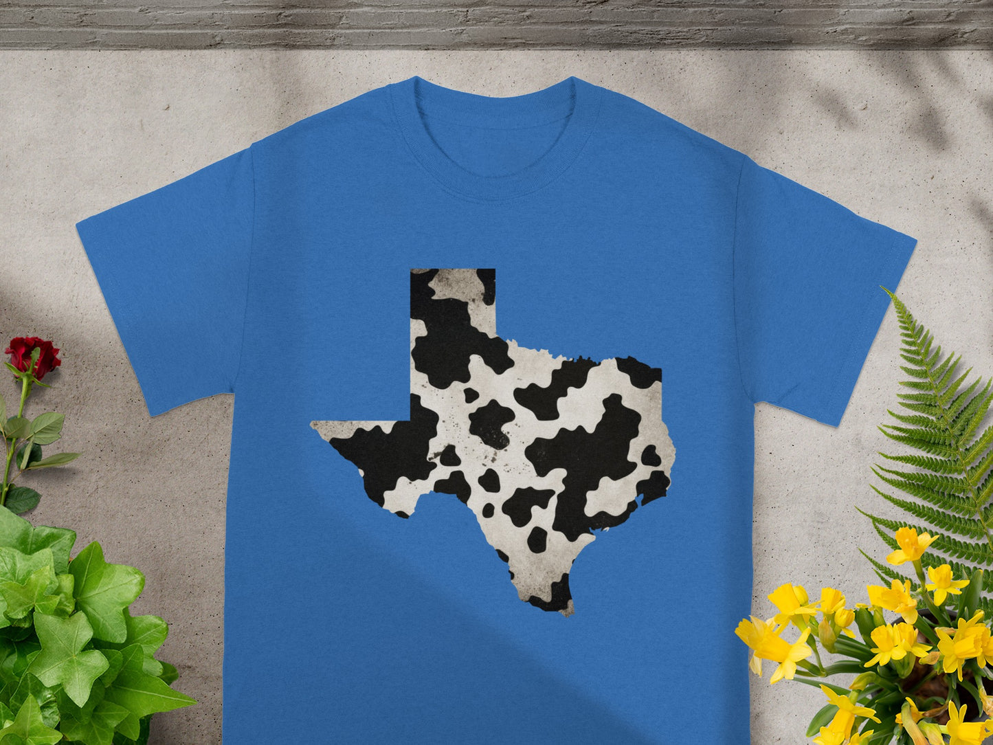 Blue t-shirt featuring Texas outline with cow print pattern.
