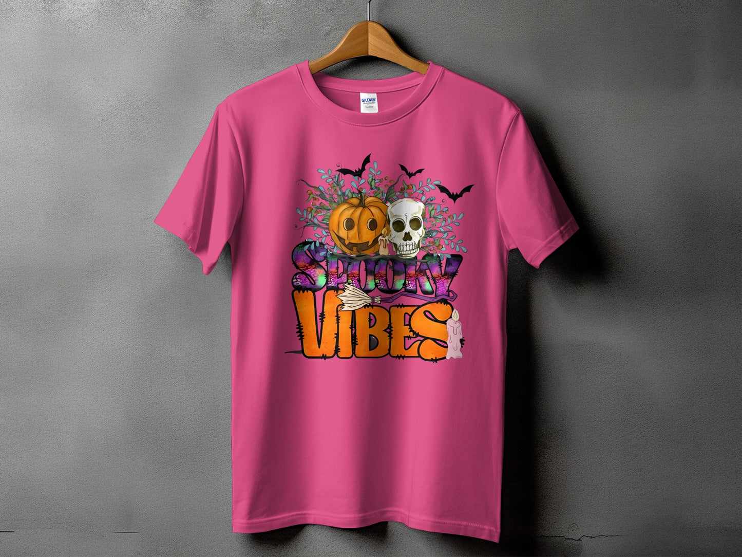 Pink t-shirt with "Spooky Vibes" text and Halloween graphics including a pumpkin and skull.
