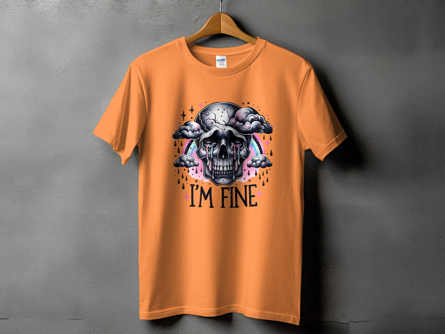 Orange t-shirt with a crying skull, clouds, rainbow, and text "I'M FINE".