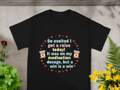 Black t-shirt with text "So excited I got a raise today! It was on my medication dosage, but a win is a win."