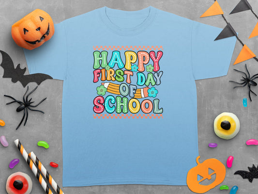 Light blue t-shirt with "Happy First Day of School" text and Halloween-themed decorations.