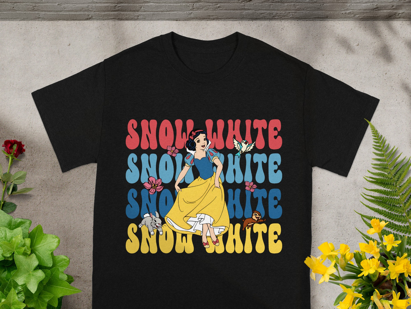 Black t-shirt with "Snow White" in colorful retro lettering.