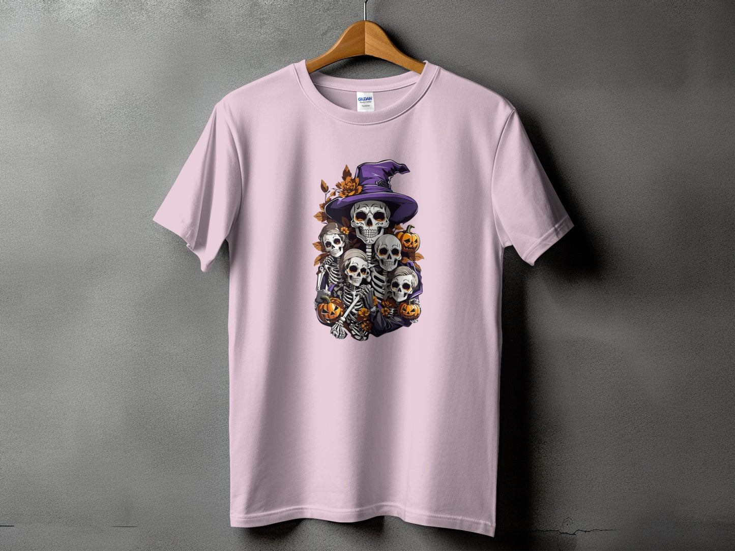 Skeleton Halloween design with witch hat, pumpkins and autumn leaves on a pink t-shirt.