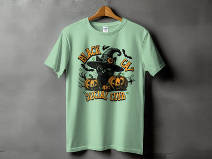 Mint green t-shirt with a black cat, pumpkins, witch hat, bats, and text "BLACK CAT SOCIAL CLUB".