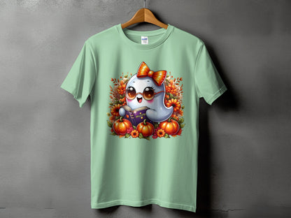 Light green t-shirt with a cute ghost reading a book surrounded by pumpkins and flowers.