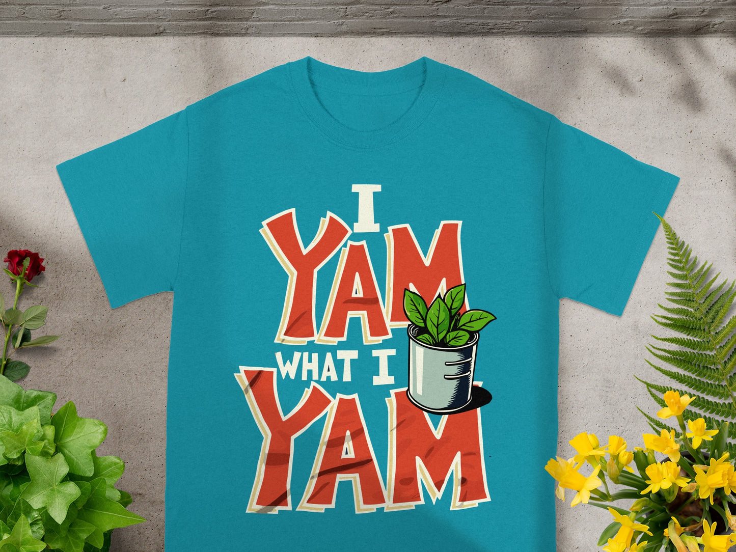 Teal t-shirt with "I Yam What I Yam" graphic and potted plant.