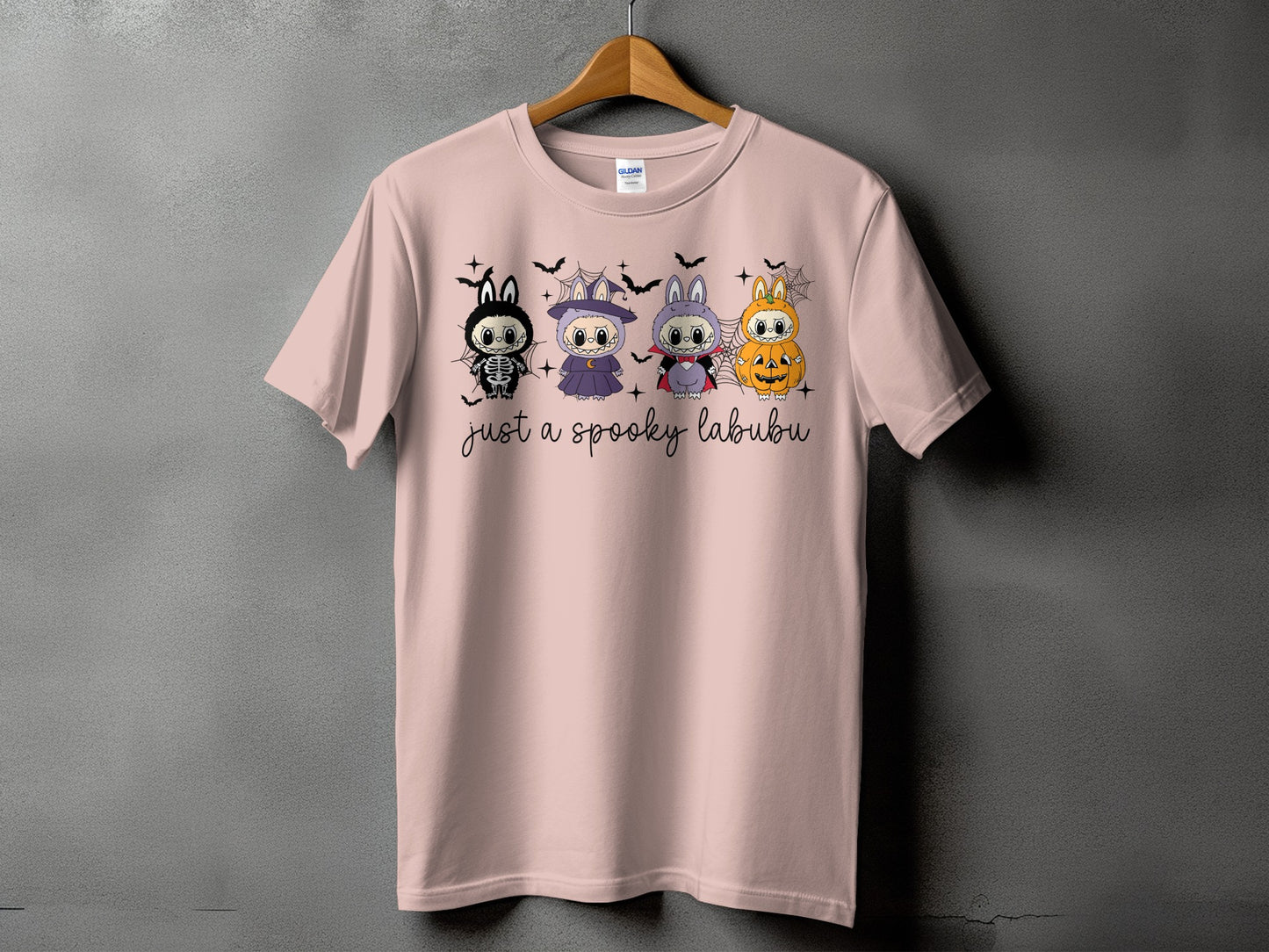 Pink t-shirt with four spooky cartoon characters and "just a spooky labubu" text.