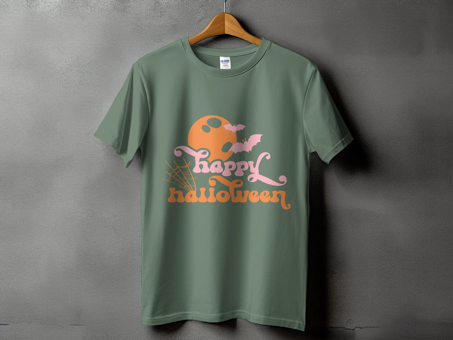 Green t-shirt with a Halloween graphic featuring an orange moon, pink bats, and text.