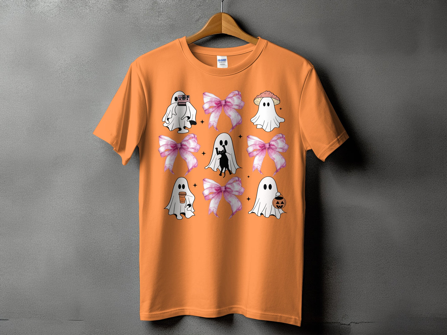Orange t-shirt with ghosts, bows, and Halloween graphics.