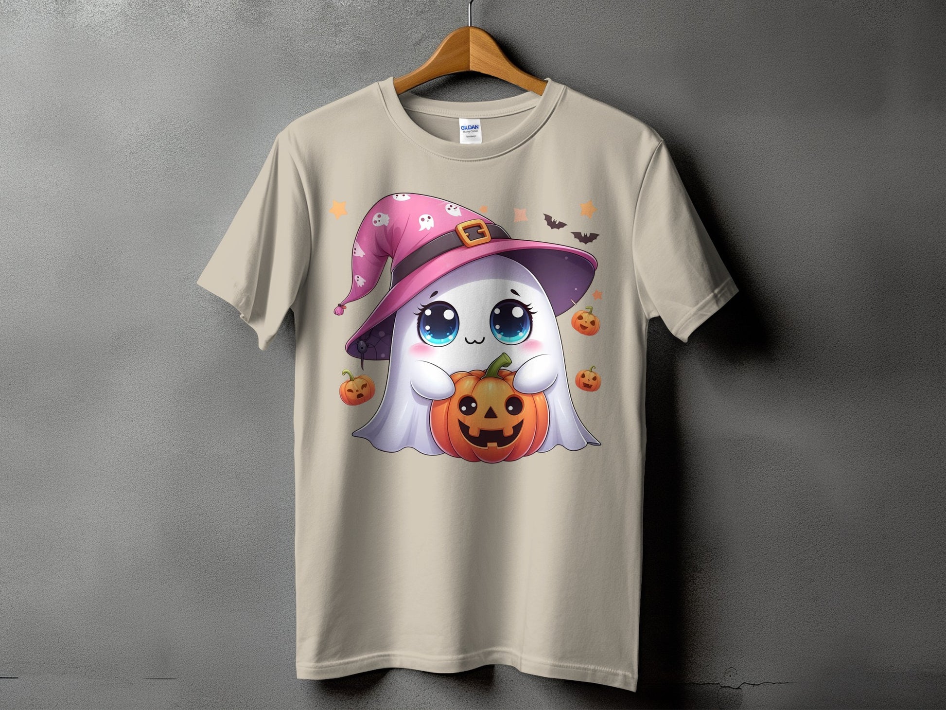 Cute ghost wearing a pink witch hat holds a jack-o'-lantern on a beige t-shirt.