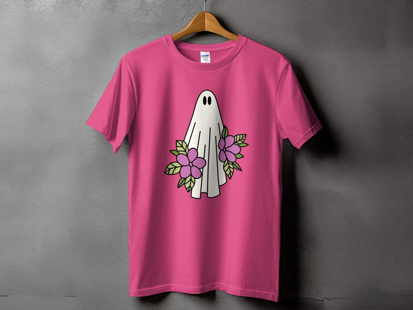 Pink t-shirt with a white ghost and purple flowers graphic.
