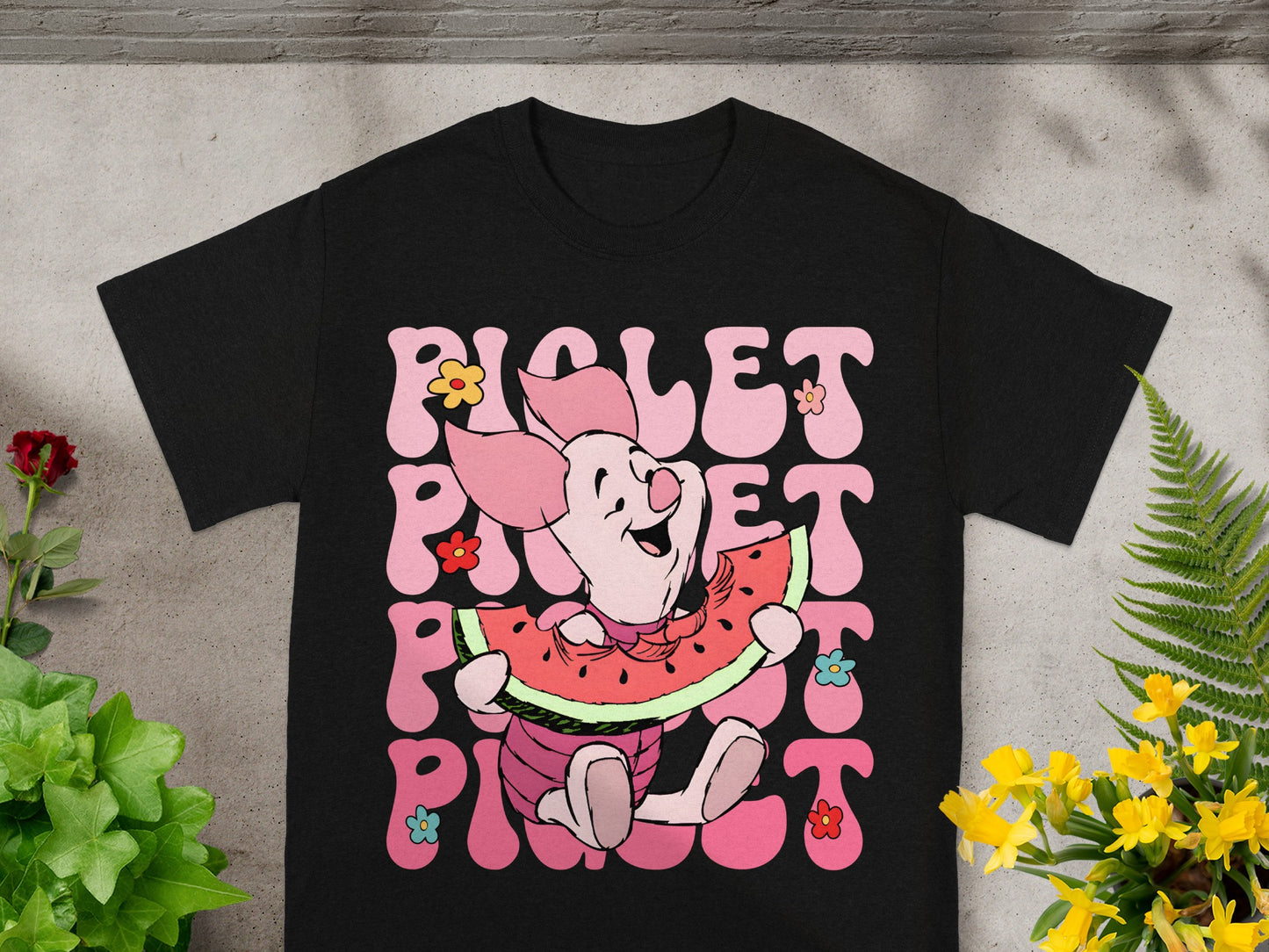 Black t-shirt with Piglet character eating watermelon and floral accents.