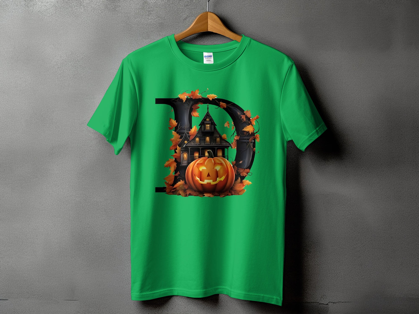 Green t-shirt with a graphic of a black letter D with a spooky house and pumpkin.