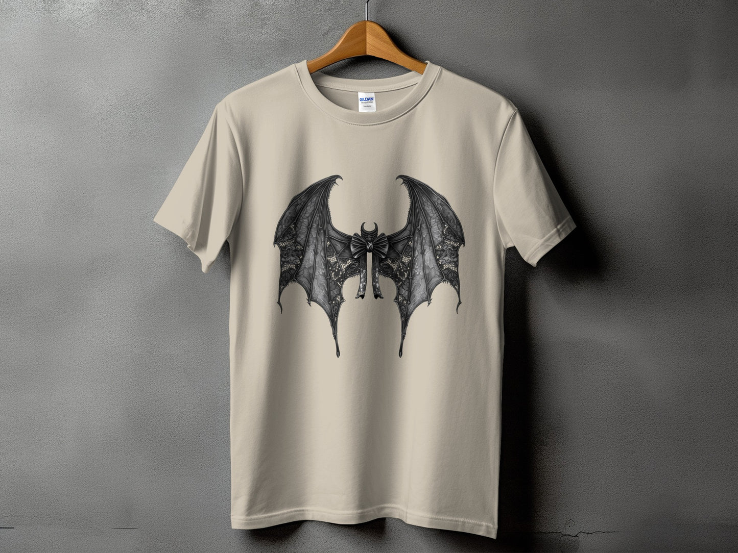 Cream t-shirt with black bat wings and bow graphic on the front.