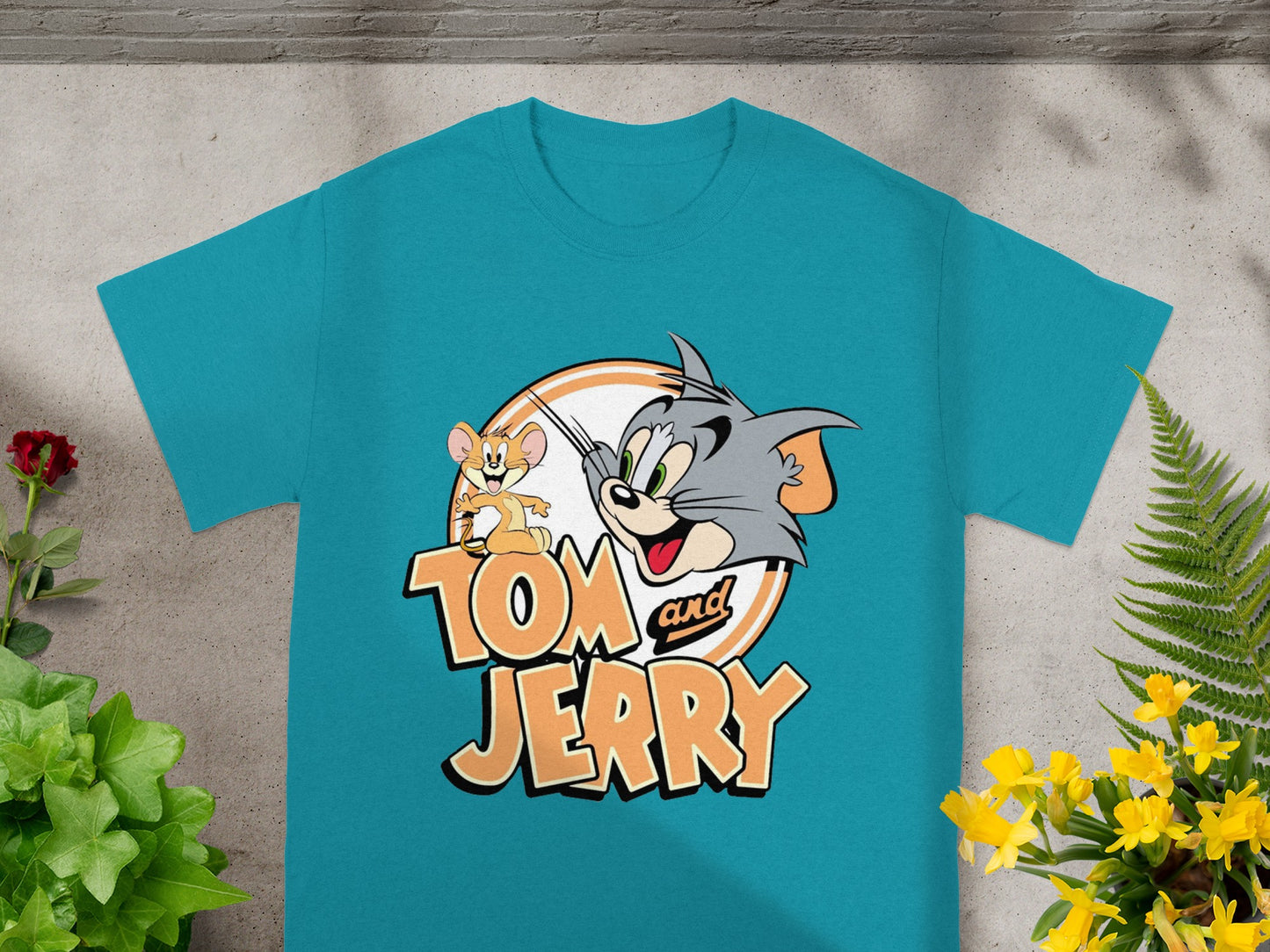 Tom and Jerry cartoon characters on a teal t-shirt.