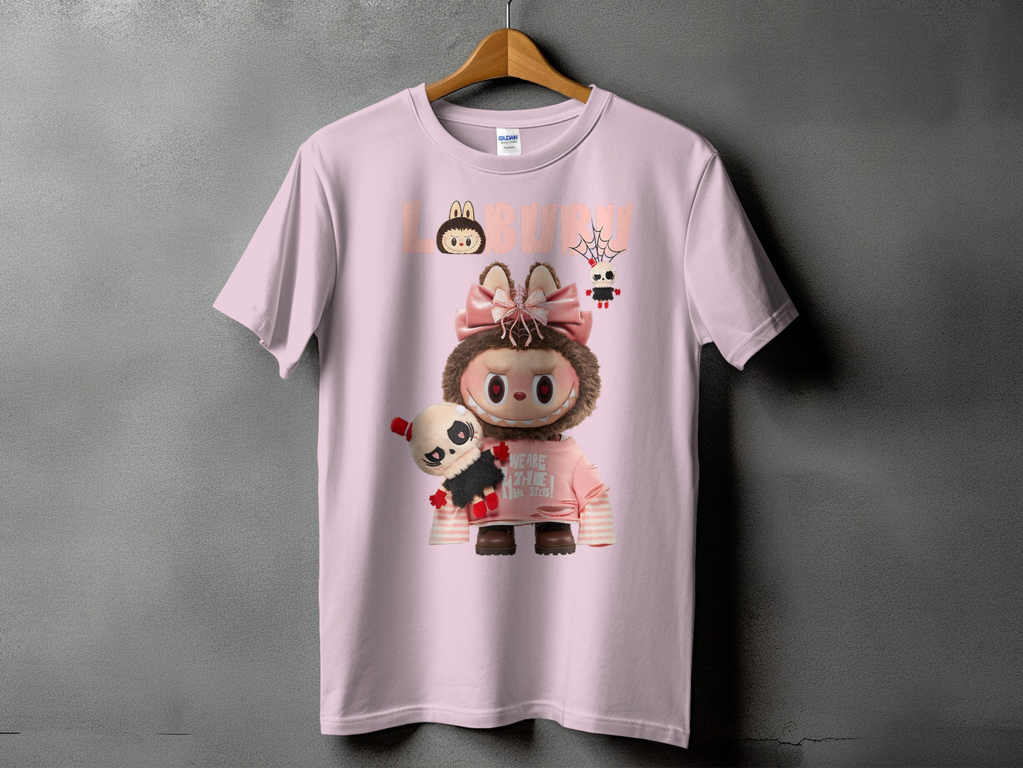 Pink t-shirt with a large graphic of a fuzzy character holding a panda plush.