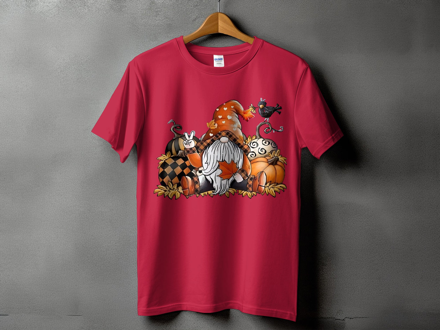 Gnome with pumpkins and leaves graphic on a red t-shirt.