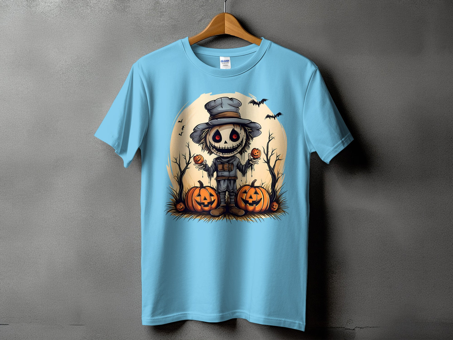 Light blue t-shirt with a cartoon scarecrow and pumpkins graphic for Halloween.