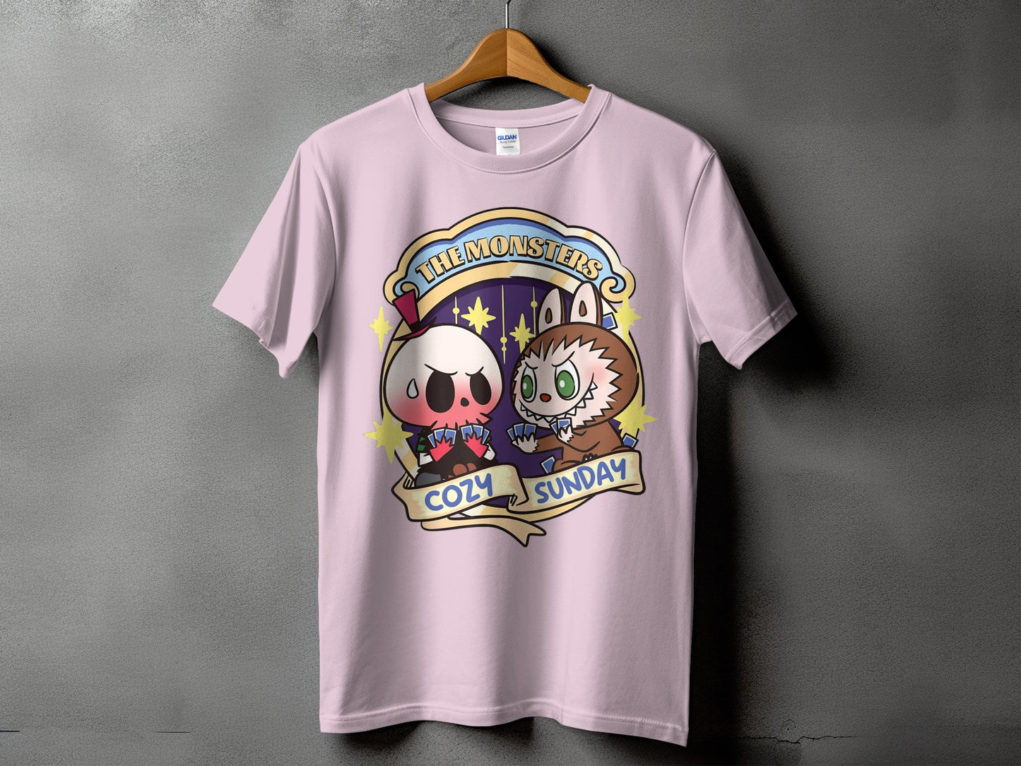 Pink t-shirt with "The Monsters Cozy Sunday" design featuring cartoon skull and werewolf characters.