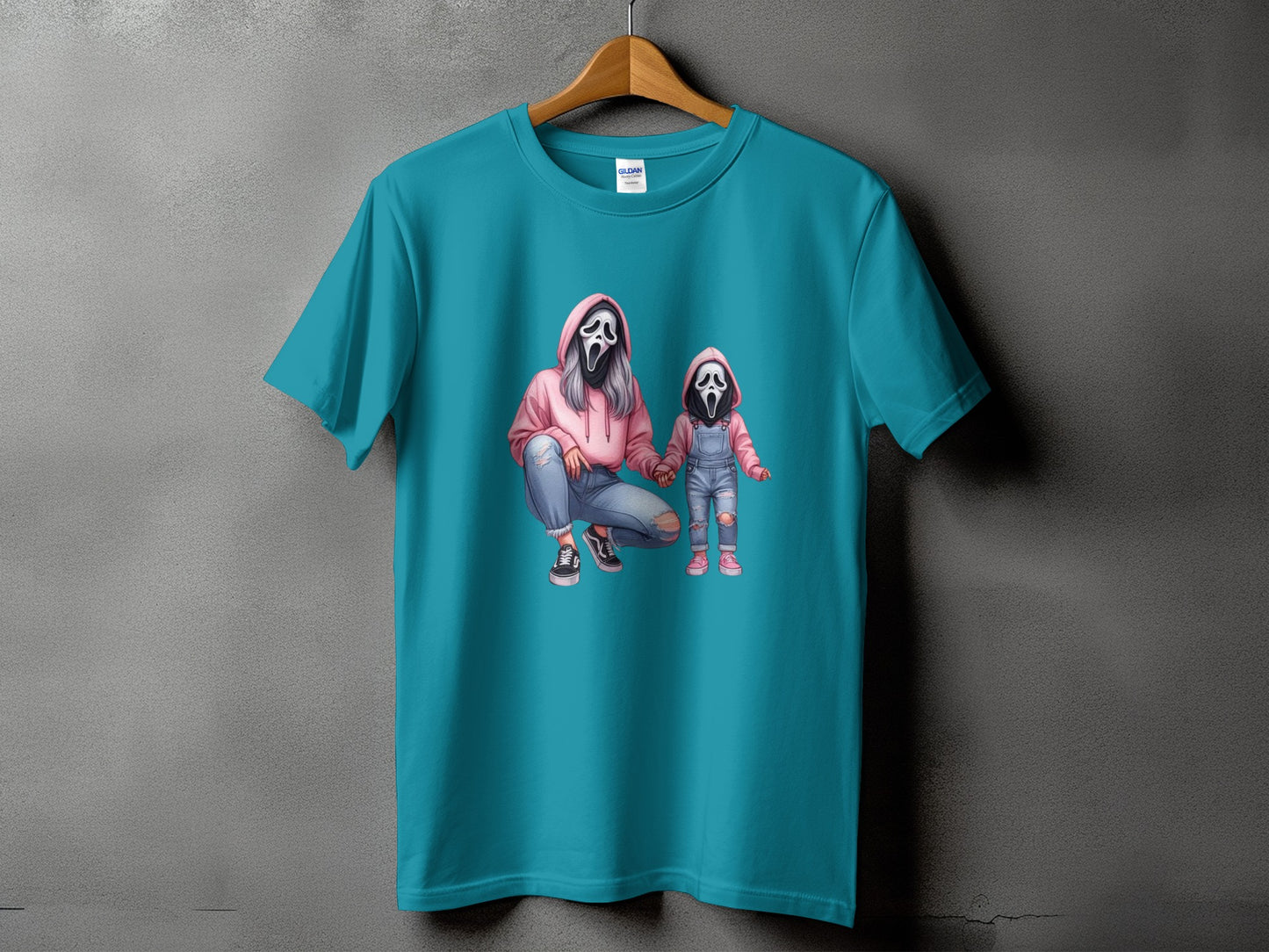 Teal t-shirt with graphic of two figures wearing ghost masks and pink hoodies.