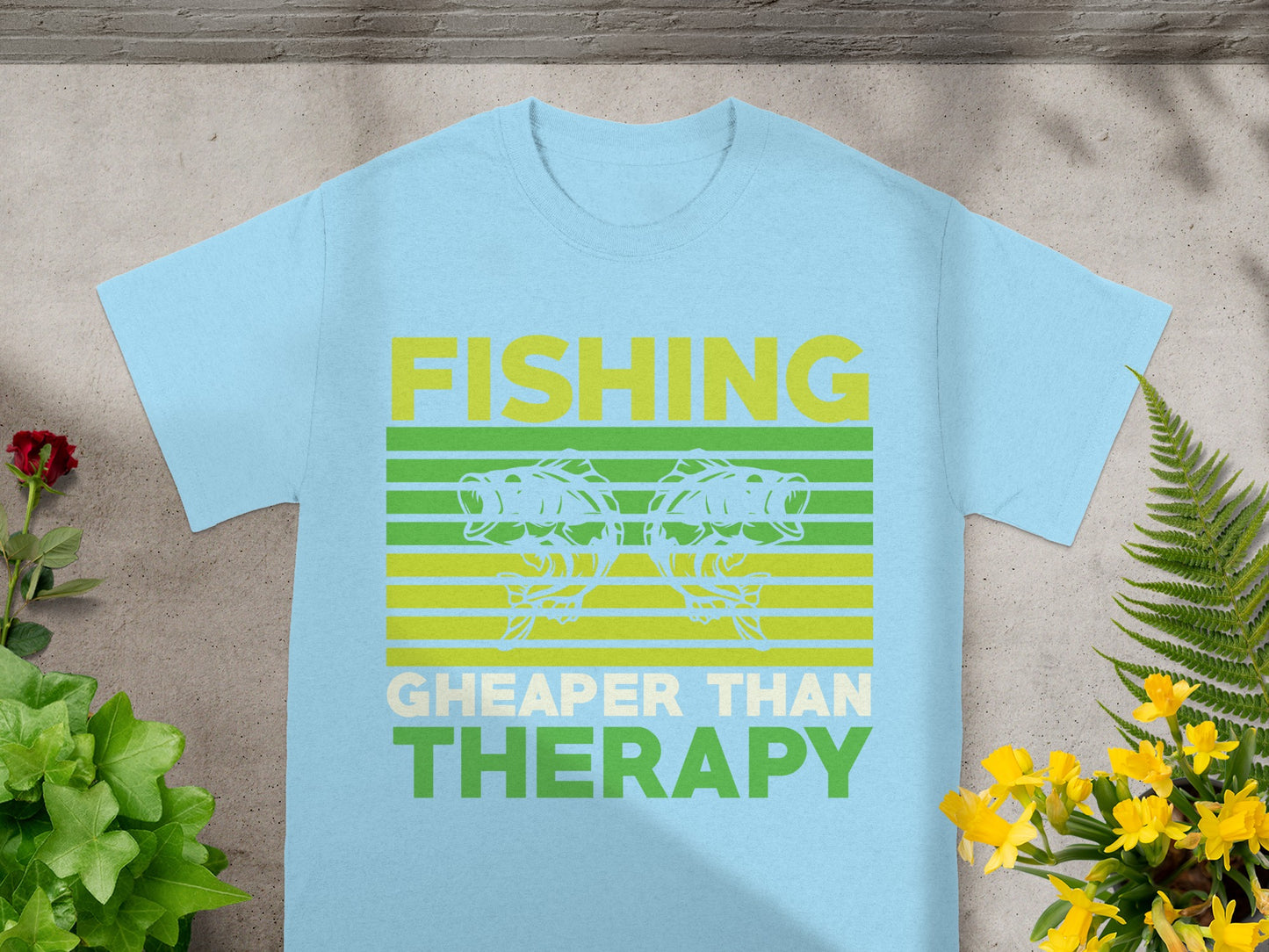 Light blue t-shirt with "FISHING CHEAPER THAN THERAPY" graphic featuring two fish.