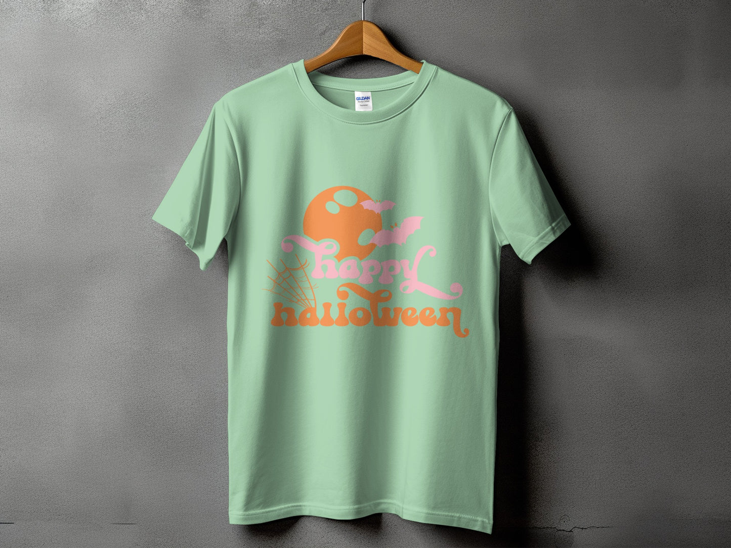 Light green t-shirt with "Happy Halloween" text, moon, bats, and spiderweb design.