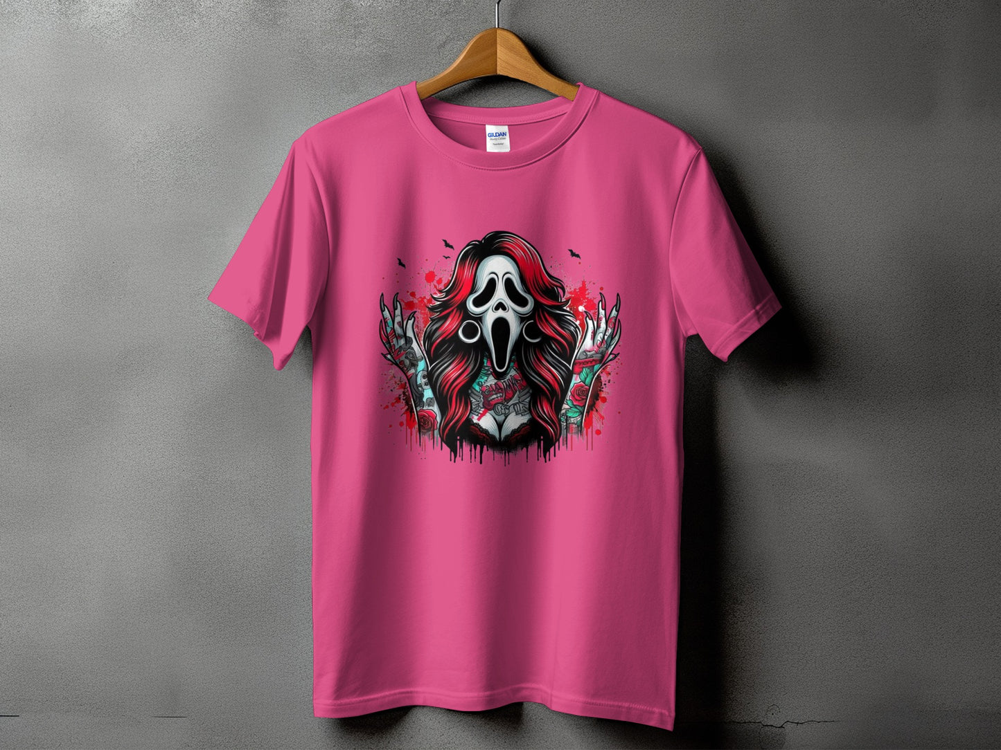 Pink t-shirt featuring a Scream mask with red hair and tattooed arms.