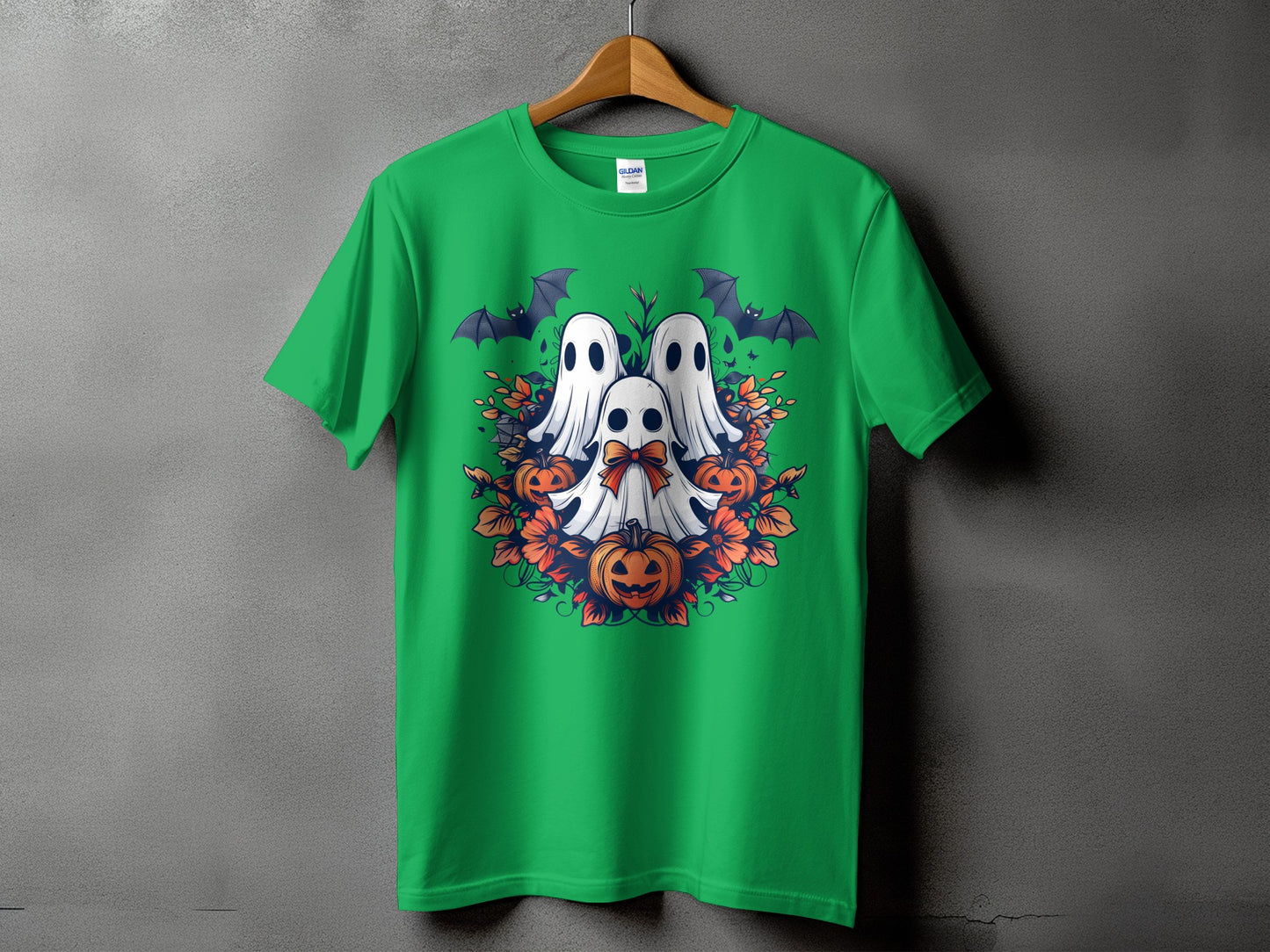 Green t-shirt with a Halloween design featuring ghosts, bats, pumpkins, and flowers.