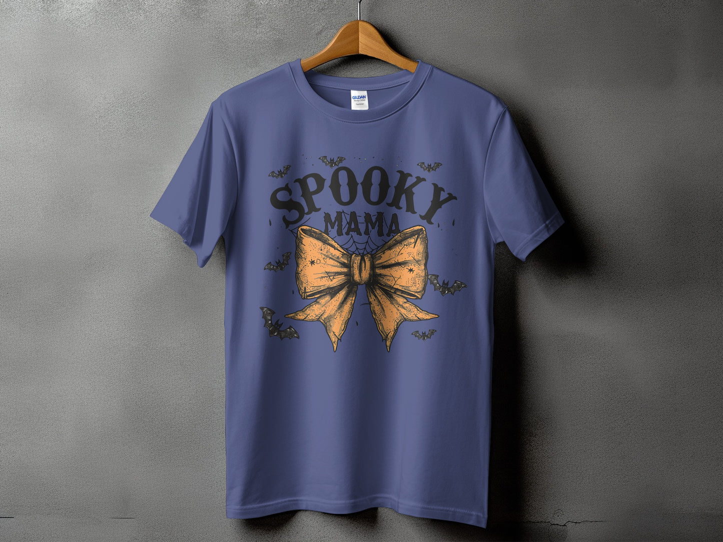 Purple t-shirt with "Spooky Mama" text and orange bow with bats.