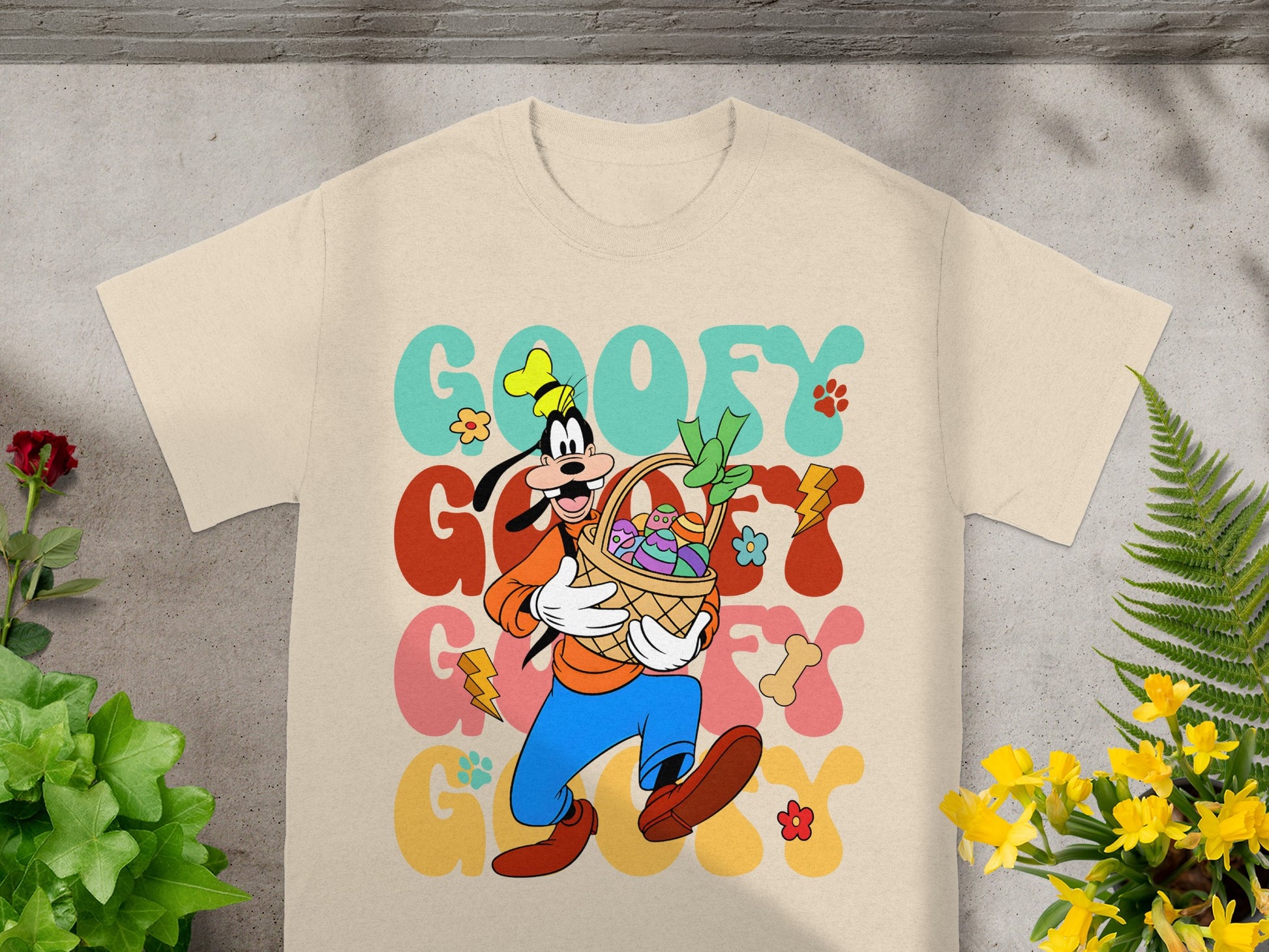 Goofy in a basket with Easter eggs and flowers, "Goofy" text.