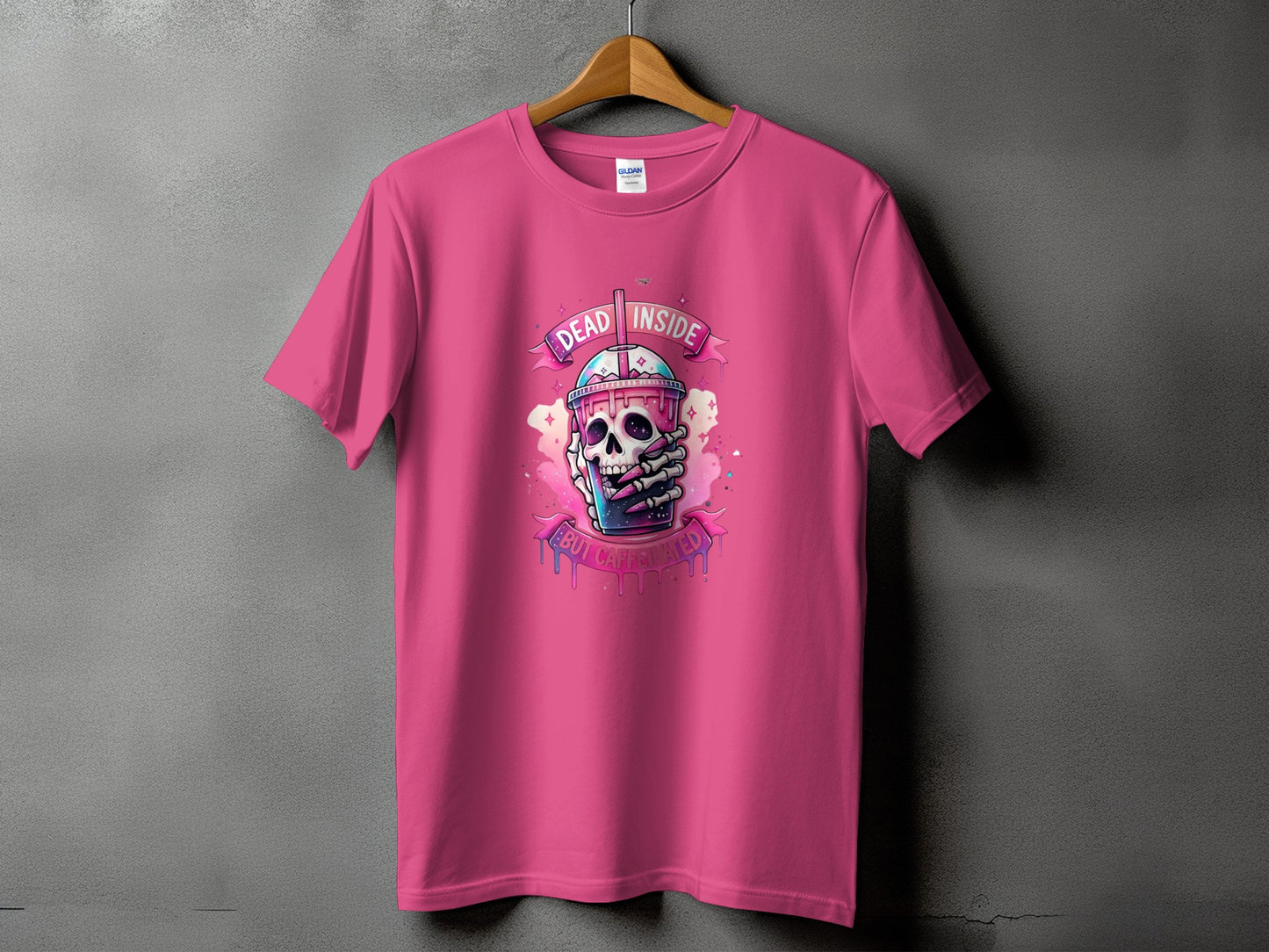 Pink t-shirt with a graphic of a skull holding a coffee cup, reading "Dead Inside But Caffeinated".