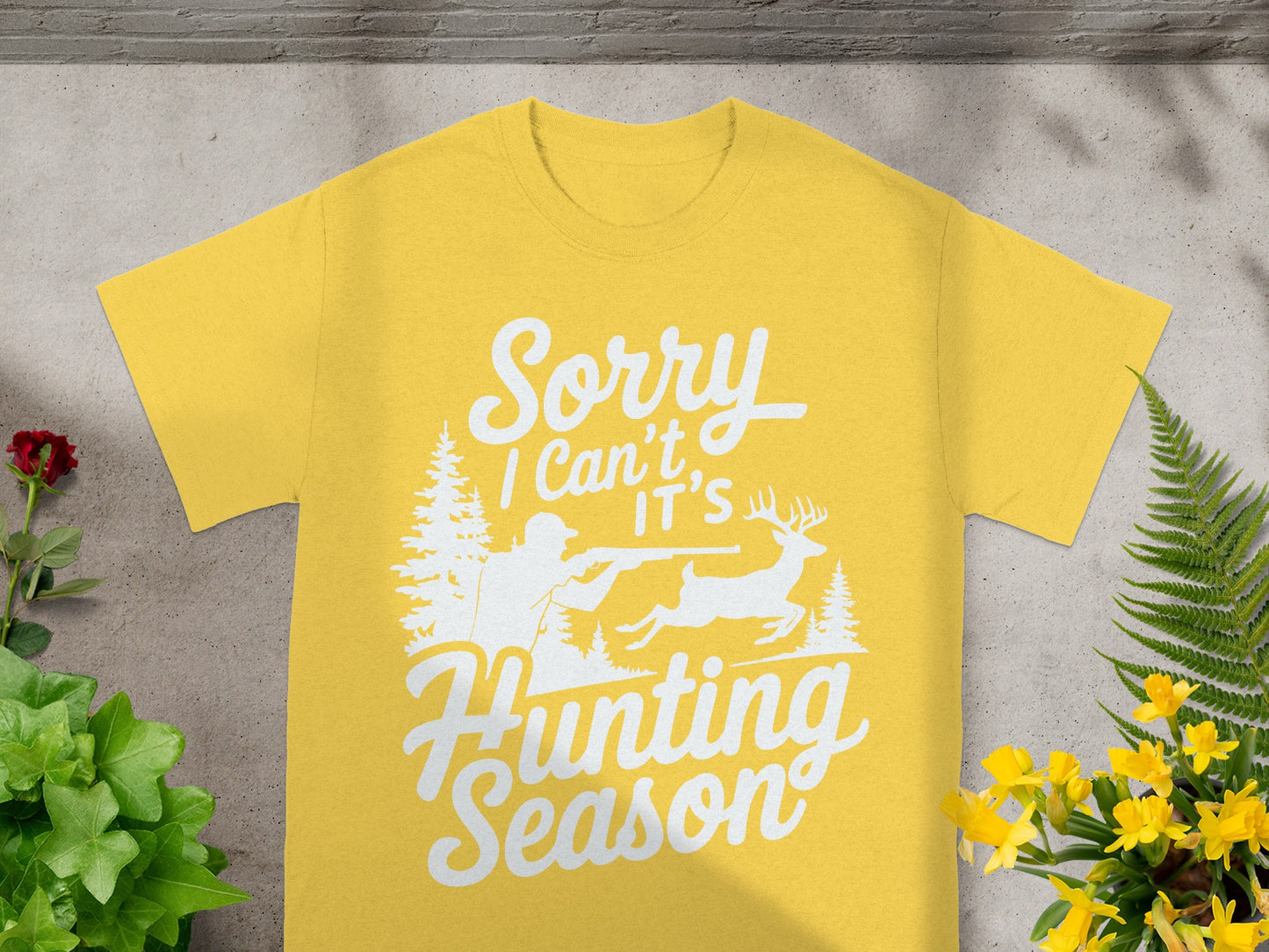 Yellow t-shirt with white text "Sorry I Can't It's Hunting Season" and forest graphic.