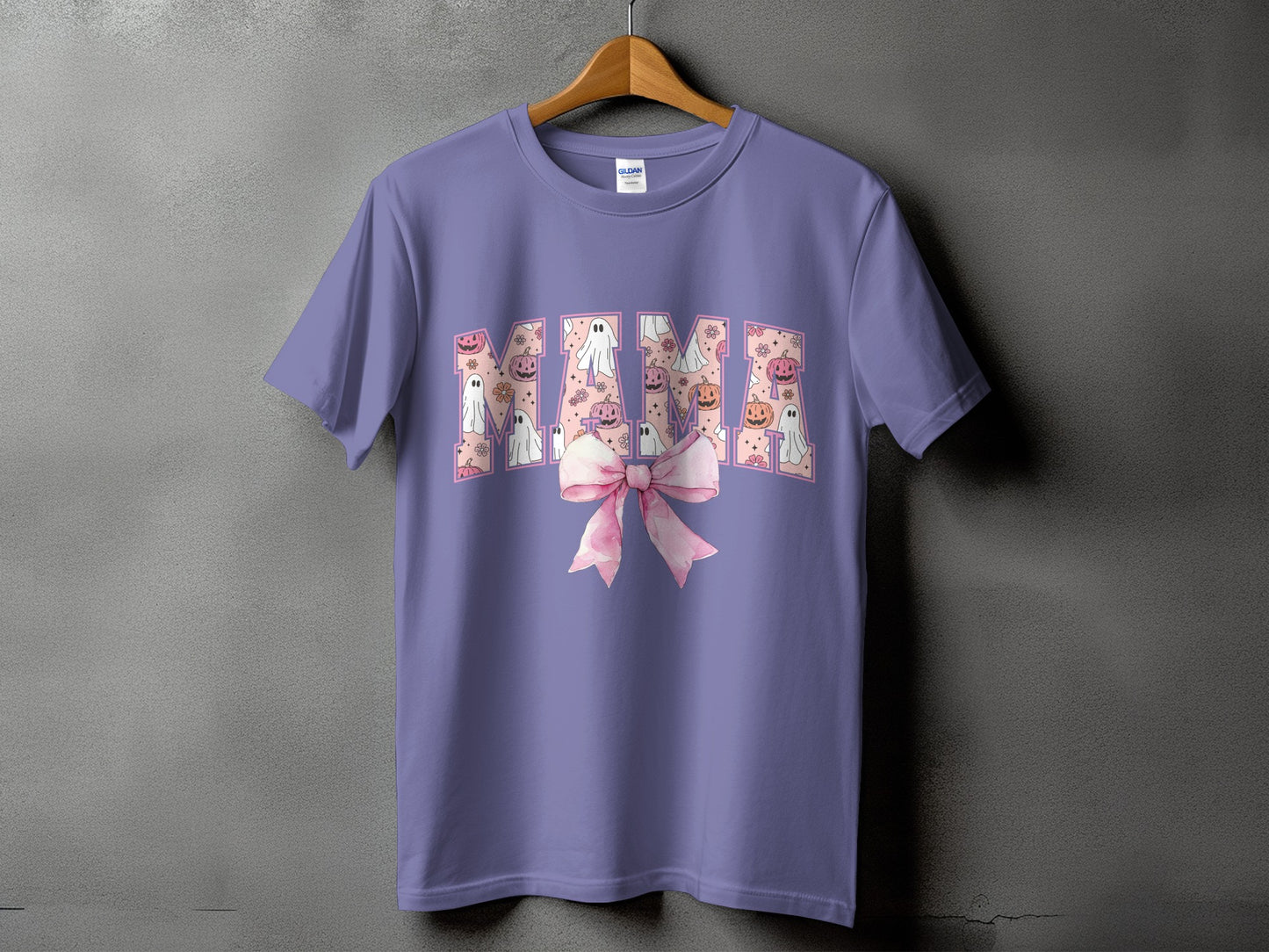 Purple t-shirt with "Mama" text filled with pumpkins and ghosts, and a pink bow.