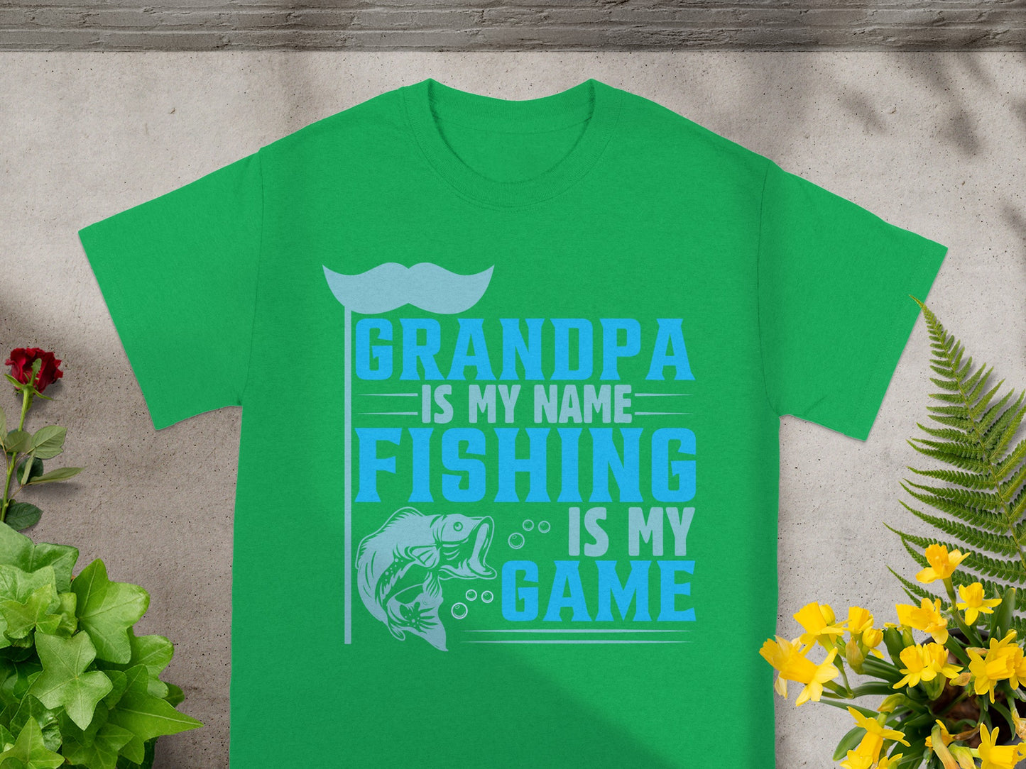 Green t-shirt with "Grandpa is my name, fishing is my game" text and fish graphic.