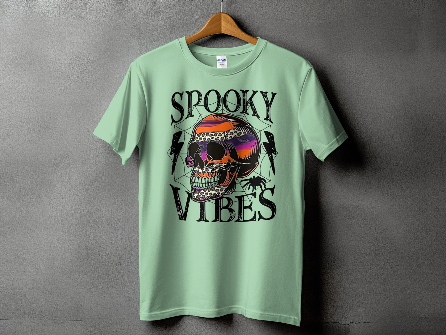 Mint green t-shirt with colorful skull graphic and text "SPOOKY VIBES".