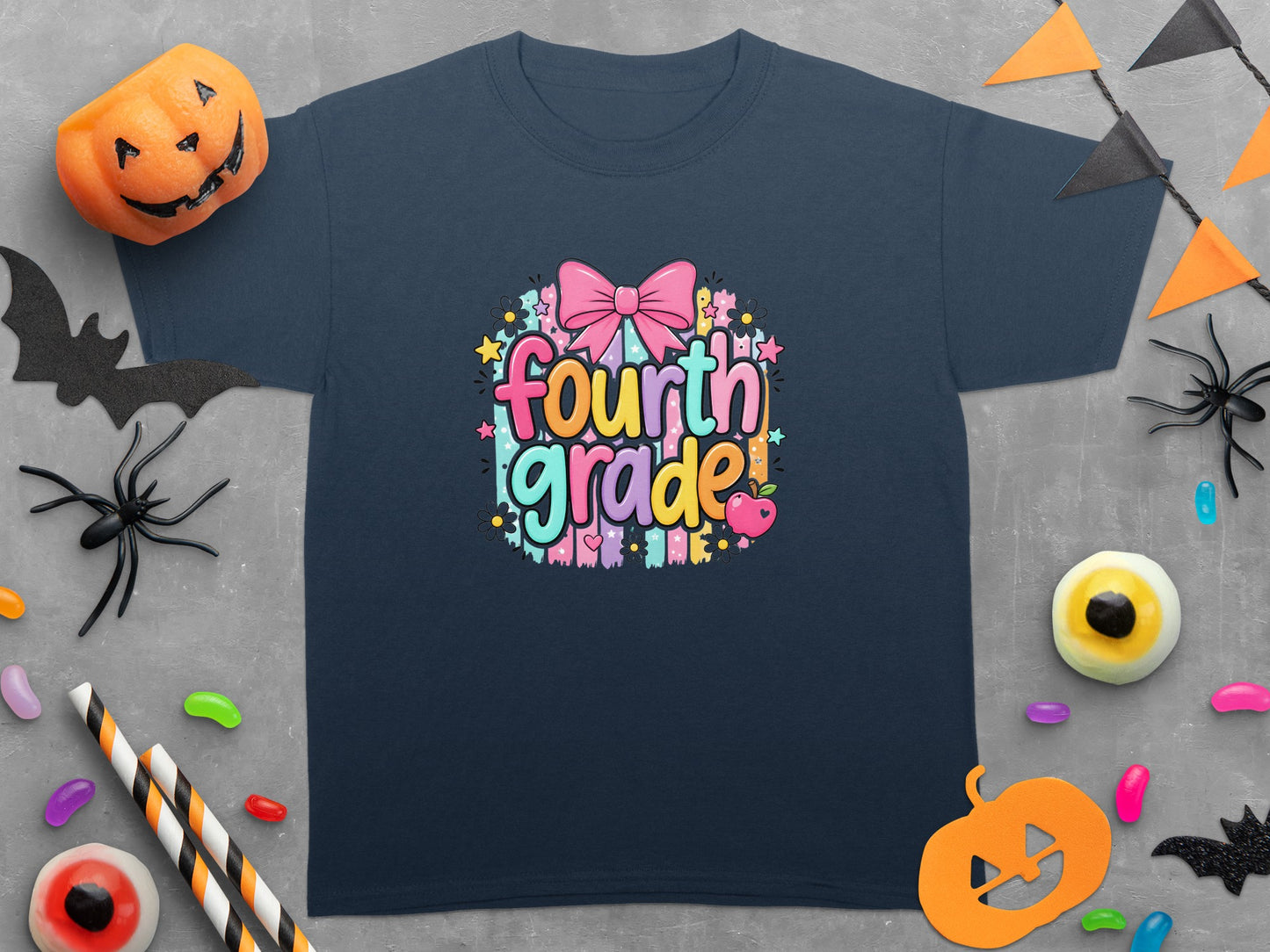 Dark blue t-shirt with "Fourth Grade" text and a pink bow, surrounded by Halloween decorations.
