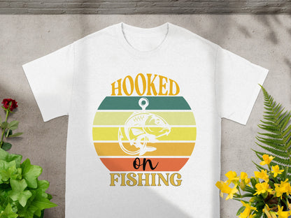 White t-shirt with "Hooked on Fishing" text and a retro sunset graphic.