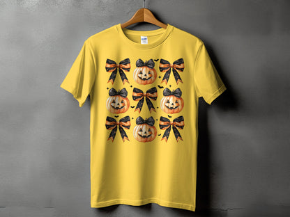 Yellow t-shirt with a repeating pattern of jack-o'-lanterns and black and orange striped bows.