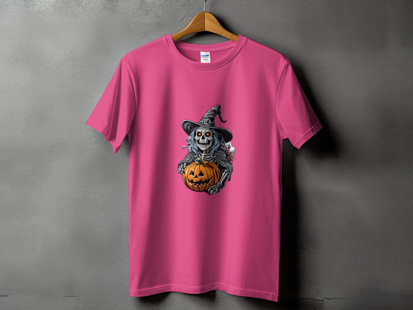 Pink t-shirt with a skeleton witch holding a jack-o'-lantern graphic.