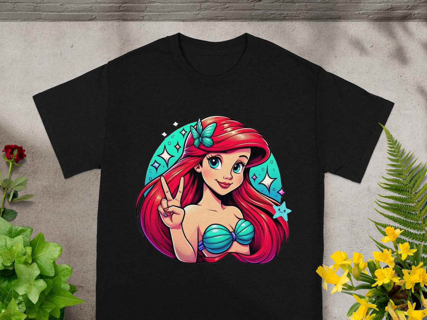Black t-shirt featuring cartoon Ariel with pink hair, green seashell top, and peace sign.