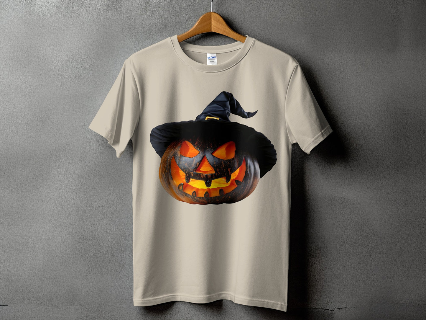 Light tan t-shirt featuring a carved, glowing jack-o'-lantern wearing a witch hat.