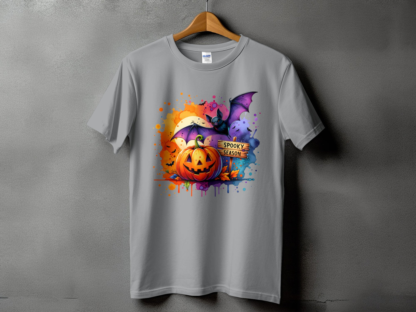 Gray t-shirt with watercolor Halloween design featuring a jack-o'-lantern, bat, and "Spooky Season" sign.