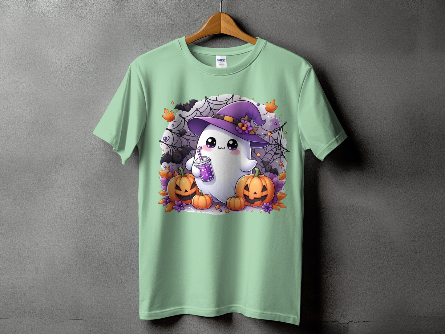 Green t-shirt with cartoon ghost wearing a witch hat and holding a drink.