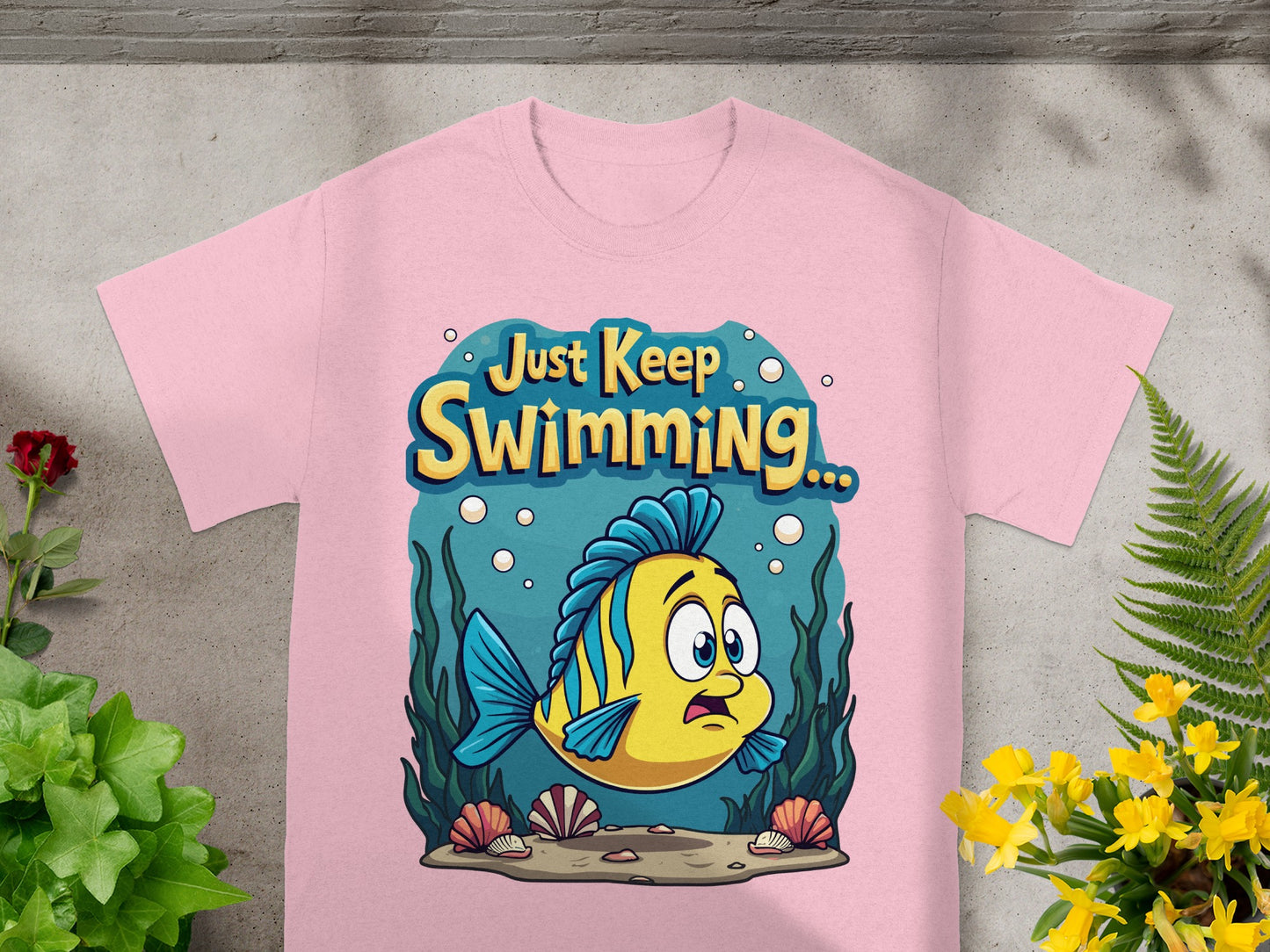 Pink t-shirt with a cartoon yellow fish and "Just Keep Swimming" text.